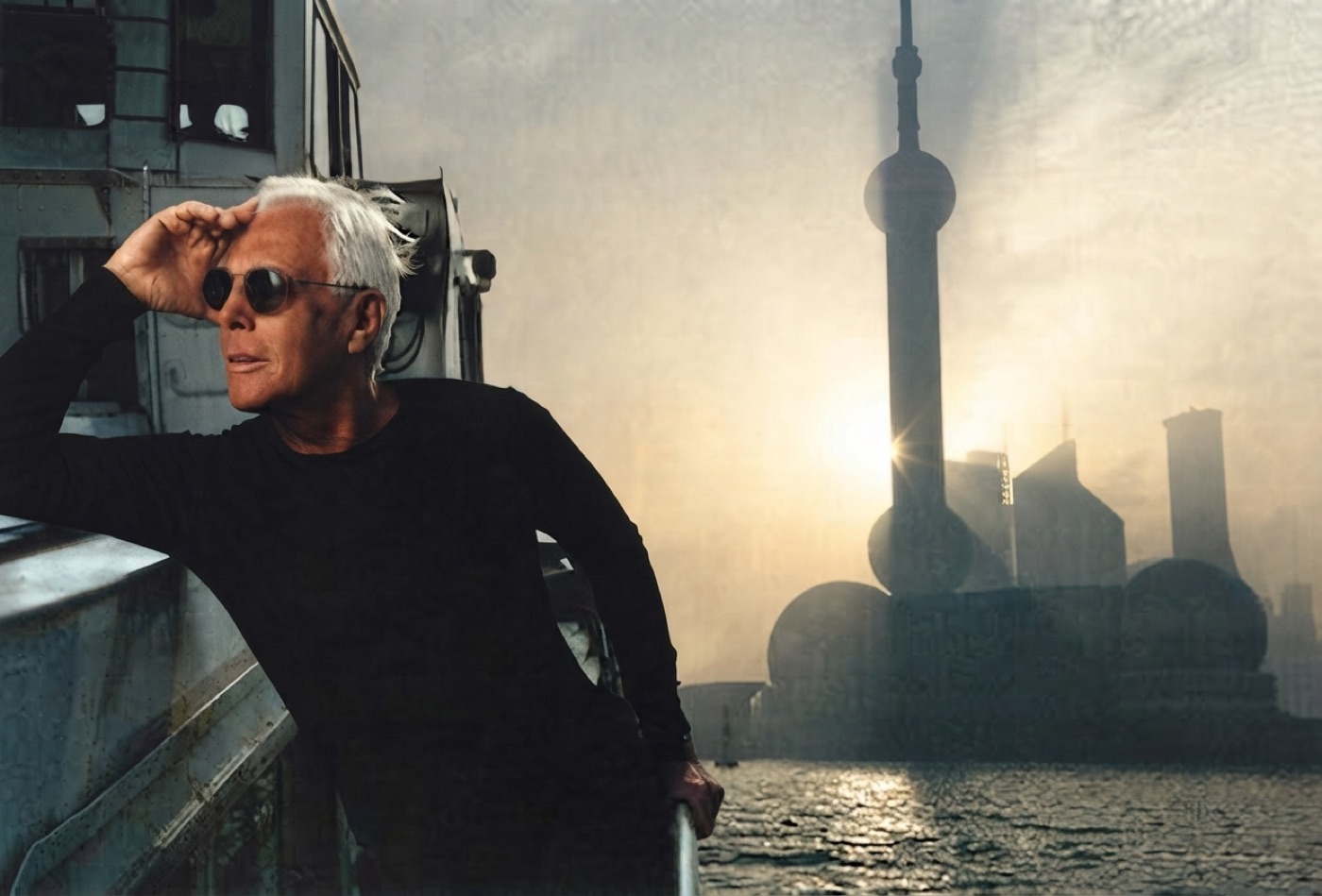 Giorgio Armani on a boat on the Bund with the Shanghai skyline at dawn behind him