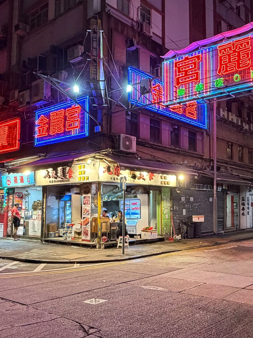 Neon signs above a street corner in Hong Kong at night