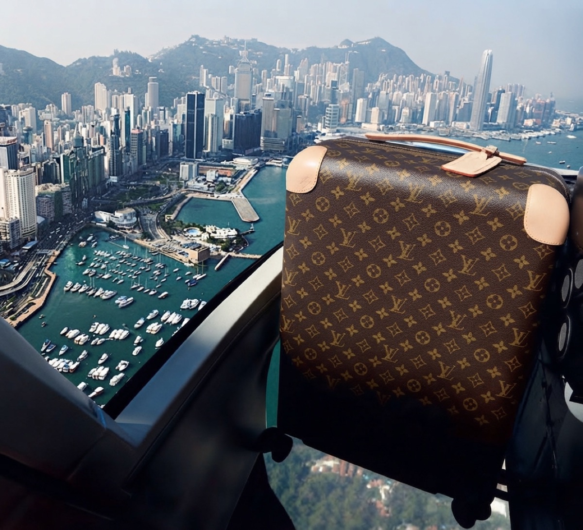 Louis Vuitton trunk in a helicopter above Hong Kong